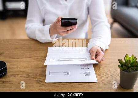 Taking Invoice Document Photo Using Phone Or Smartphone Stock Photo