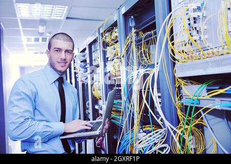 young engeneer business man with thin modern aluminium laptop in network server room Stock Photo