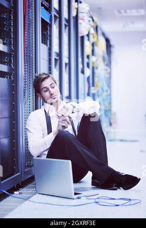 young engeneer business man with thin modern aluminium laptop in network server room Stock Photo