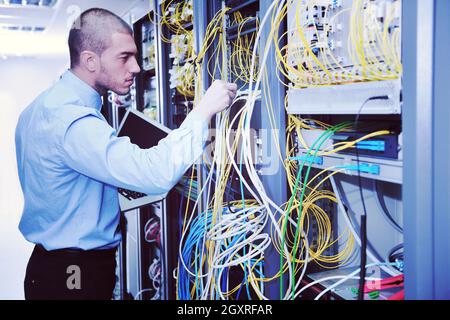 young engeneer business man with thin modern aluminium laptop in network server room Stock Photo