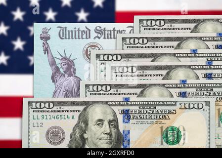 Six Hundred Dollars and United States IRS Stimulus Check Resting on American Flag. Stock Photo