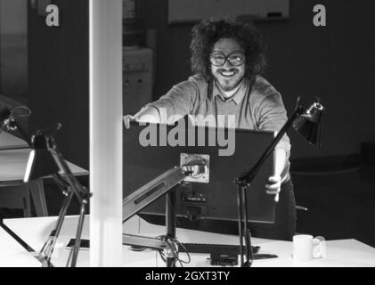 Young programmer trying to fix his lcd monitor at work Stock Photo