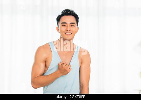 Happy Asian young man Doing Exercises at Home Stock Photo