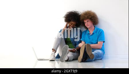 startup business and new mobile technology concept with young multiethnic couple in modern bright office interior working on laptop and tablet compute Stock Photo