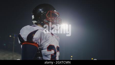 portrait of young confident American football player  standing on field at night Stock Photo