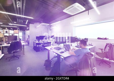 software developers working everyday job writing programming code at modern sunny bright open plan office Stock Photo