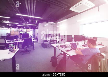 software developers working everyday job writing programming code at modern sunny bright open plan office Stock Photo