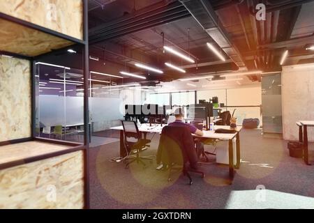 software developers working everyday job writing programming code at modern sunny bright open plan office Stock Photo