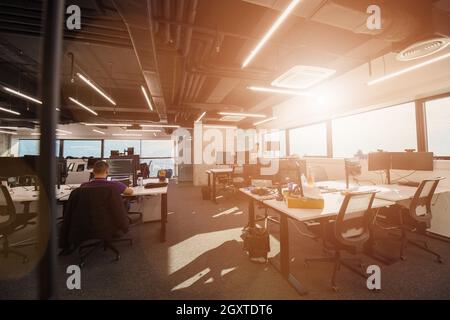 software developers working everyday job writing programming code at modern sunny bright open plan office Stock Photo