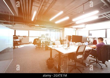 software developers working everyday job writing programming code at modern sunny bright open plan office Stock Photo