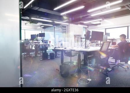 software developers working everyday job writing programming code at modern sunny bright open plan office Stock Photo