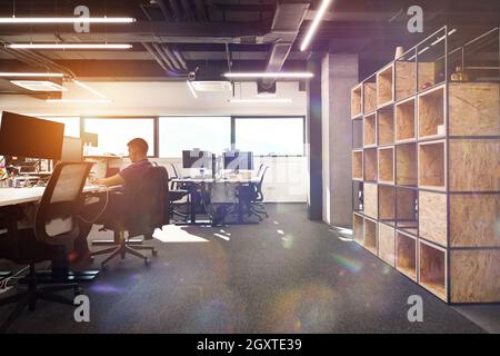 software developers working everyday job writing programming code at modern sunny bright open plan office Stock Photo