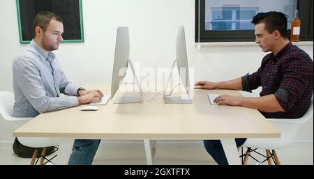 In the Creative Agency Office. Men Works at the Desktop Computer in modern startup office Stock Photo