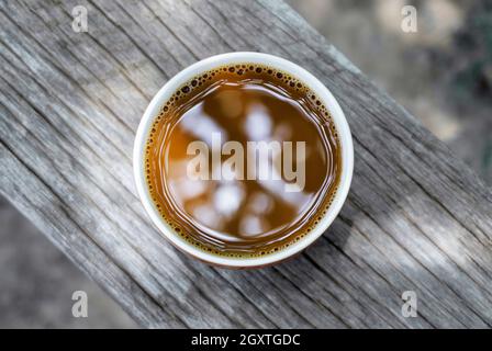Top view of a brown hot coffee cup on an old wood table vintage style with light nature Stock Photo