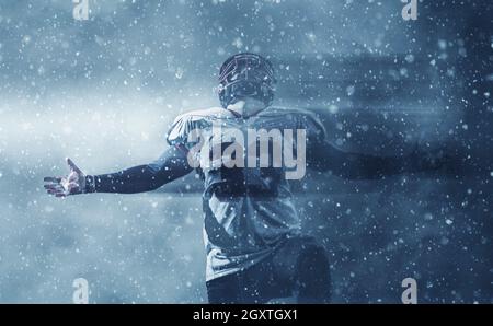american football player celebrating after scoring a touchdown on field at night Stock Photo