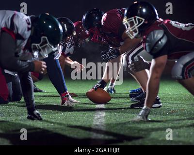 american football players are ready to start on field at night Stock Photo