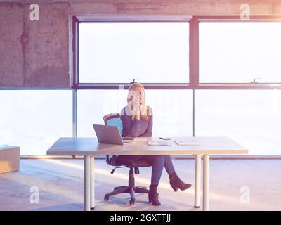 portrait of young female architect on construction site checking documents and business workflow using laptop computer with sunlight through windows i Stock Photo