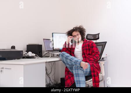 young graphic designer in bathrobe working at home office using computer Stock Photo