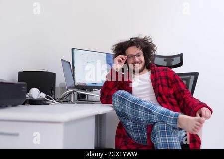 young graphic designer in bathrobe working at home office using computer Stock Photo