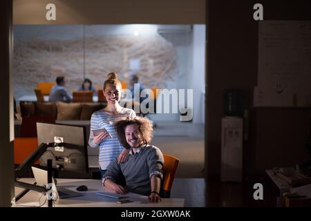 Two young designers are working on a new project in the night office using modern technology Stock Photo