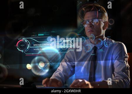 Young man working on computer at night in dark office. The designer works in the later time. Stock Photo