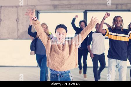 happy multiethnic business team dancing during moving in at new unfinished startup office building Stock Photo