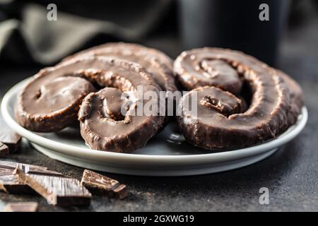 Sweet pastry palmeritas with chocolate icing on plate. Stock Photo
