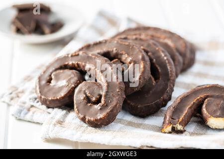 Sweet pastry palmeritas with chocolate icing on white table. Stock Photo