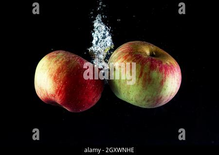 Two apples in water on a black background. Stock Photo