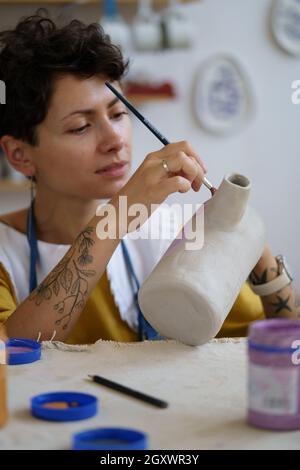 Artist student girl painting pottery at art studio Stock Photo - Alamy