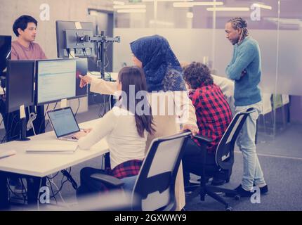 young multiethnics business team of software developers working together using laptop computer while writing programming code at modern startup office Stock Photo