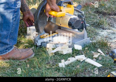 Worker Using Electric Miter Saw At Constrcution Site Stock Photo