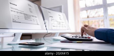 Bookkeeper Accountant Calculating Tax Invoice On Office Computer Stock Photo