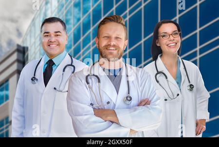 Group Of Mixed Race Male and Female Doctors or Nurses In Front of Hospital Building. Stock Photo