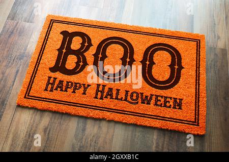 Boo, Happy Halloween Orange Welcome Mat On Wood Floor Background. Stock Photo