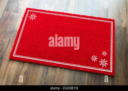 Blank Holiday Red Welcome Mat With Snow Flakes On Wood Floor Background. Stock Photo