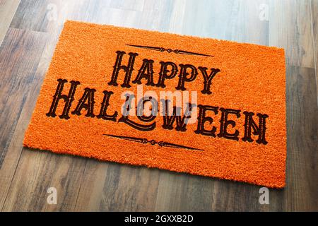 Happy Halloween Orange Welcome Mat On Wood Floor Background. Stock Photo