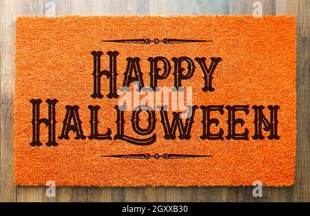 Happy Halloween Orange Welcome Mat On Wood Floor Background. Stock Photo