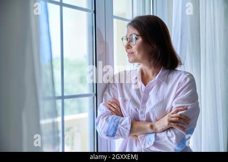 Portrait of a mature confident woman looking out the window Stock Photo
