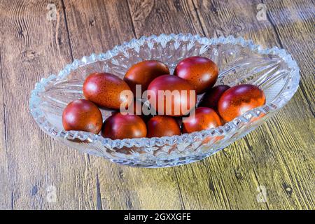 Painted Easter eggs in a crystal vase. Red painted chicken eggs for easter. Stock Photo