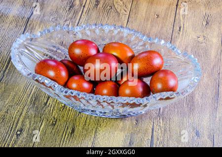 Painted Easter eggs in a crystal vase. Red painted chicken eggs for easter. Stock Photo