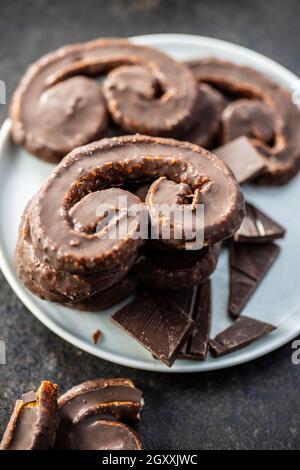 Sweet pastry palmeritas with chocolate icing on plate. Stock Photo