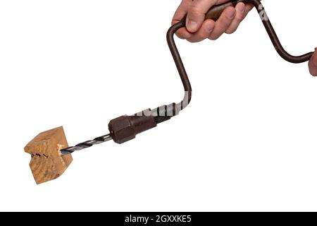 Man drilling a hole in a piece of woodwork with antique hand drill (chest lyre) and a clamped new wood bit. Clipping path. Macro. Isolated on white ba Stock Photo