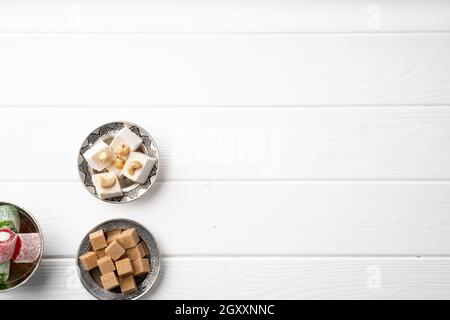 Top view of Turkish delight and brown cubed sugar in oriental dishware on table Stock Photo