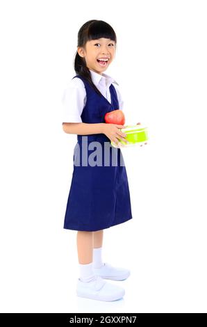 Asian primary school girl holding lunch box. Healthy eating concept for schoolchild. Stock Photo