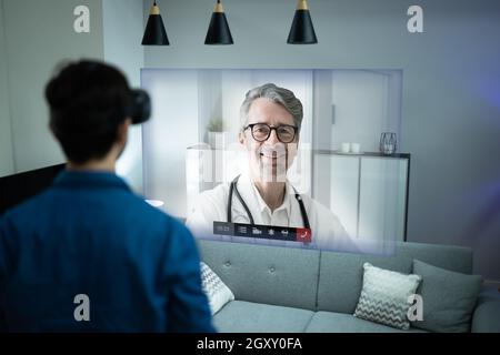 Online Video Conference With Medical Doctor Using VR Headset Stock Photo