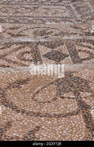 Decorated pebble stone street. Textured pavement sidewalk. Vertical Stock Photo