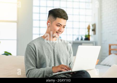 young man  wear earphone and using video conference  on laptop computer at home Stock Photo