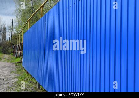 Diagonal pattern of metal profile. Fences from the galvanized iron painted by a polymeric covering. Stock Photo