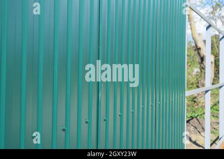 Diagonal pattern of metal profile. Fences from the galvanized iron painted by a polymeric covering. Stock Photo